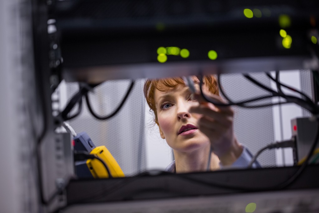 Technician using digital cable analyzer on server