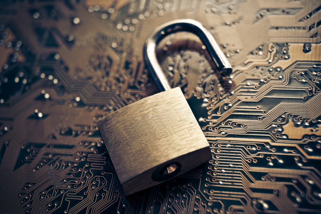Open padlock on a motherboard signifying security breach