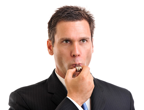 Businessman blowing whistle on white