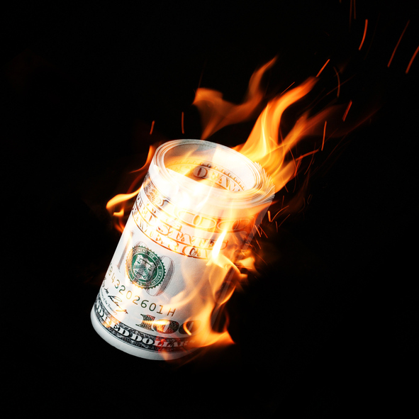 Burning one hundred dollar bills rolled