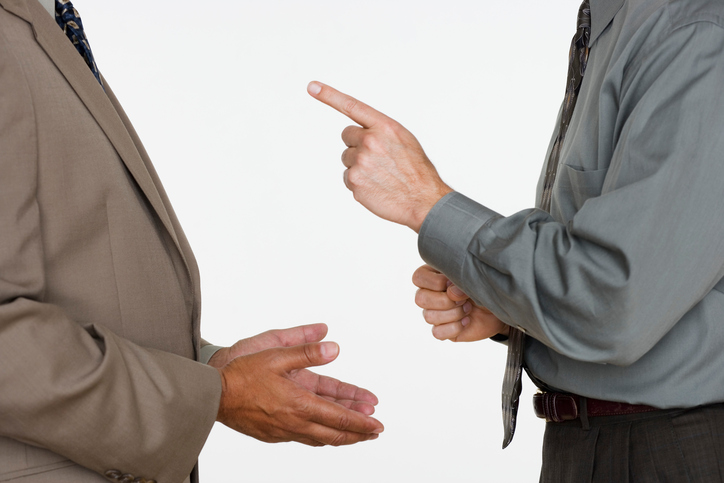 Mid section of two businessmen facing each other with hands gesturing