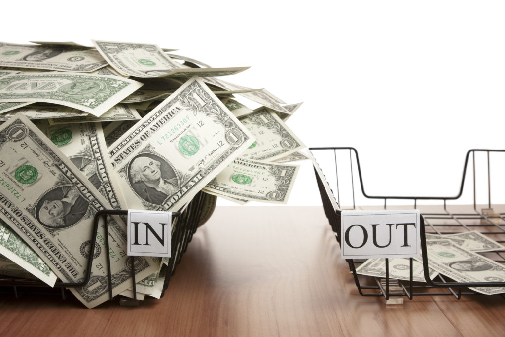 In tray overflowing with dollar notes and empty out tray
