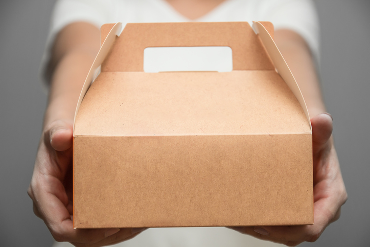 A woman in white T-shirt stood bringing a snack box