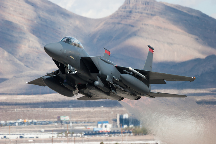 F-15E Strike Eagle flying past mountains