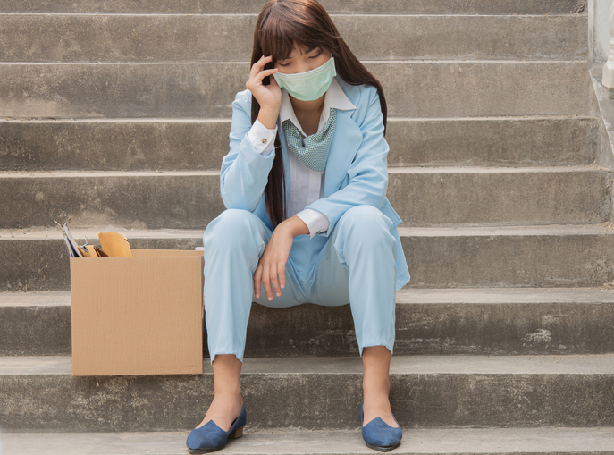 The girl sits sadly on the cement stairs