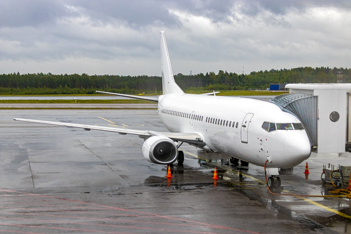White Boeing 737-33R parked at Scandinavian airport terminal loading passengers