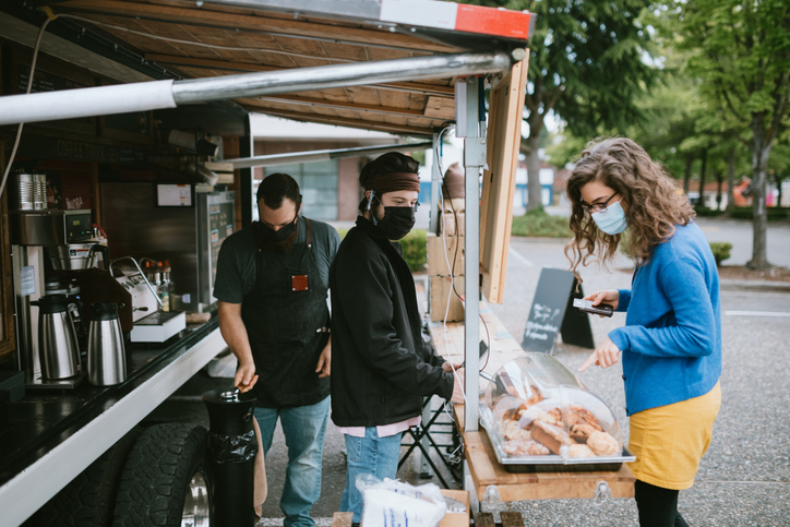Masked Customer Orders Coffee And Snacks at Food Truck