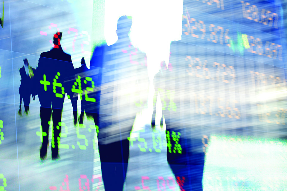 Traders in financial district with trading screen data.